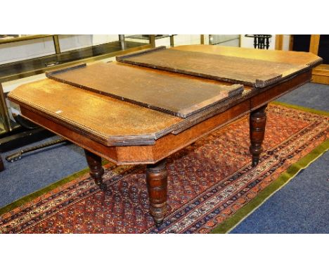 An oak telescope dining table with two additional leaves, raised on turned supports with ceramic castors, 82cm high x 130cm w