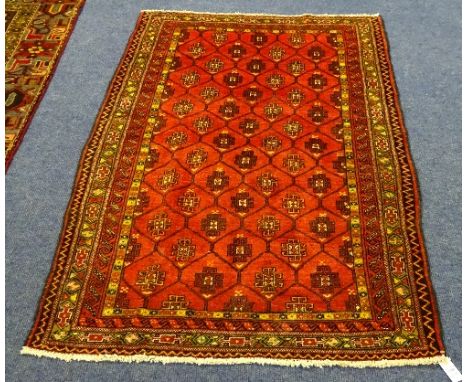 An Eastern carpet, the allover diamond motif on red ground with multiple yellow, red and brown geometric border, 168 x 104cm