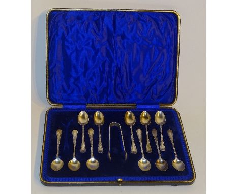 A cased set of 11 silver teaspoons with non matching sugar tongs, hallmarks for Sheffield 1902 JR, with engine turned decorat