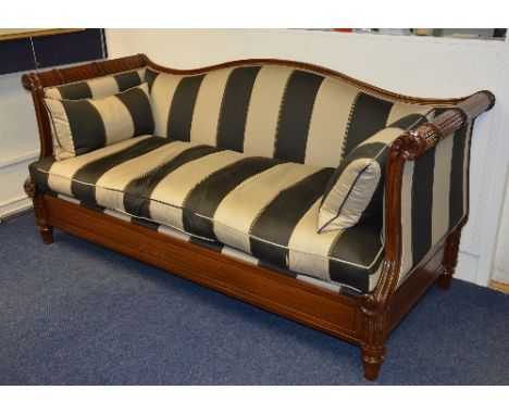 A reproduction mahogany framed settee, upholstered in striped fabric, with rolled arm rests, terminating in scrolls, 90cm hig