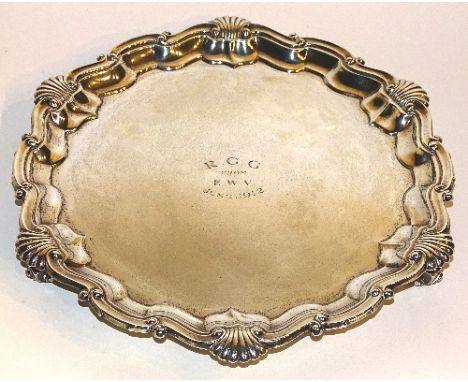 A silver salver, hallmarks for London 1913 Goldsmiths & Silversmiths Co Ltd, the pie crust edge with shell finial decoration,