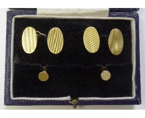 An 18ct gold cufflink and stud set, of plain, oval, engine turned design comprising two studs and a pair of cufflinks in fitt