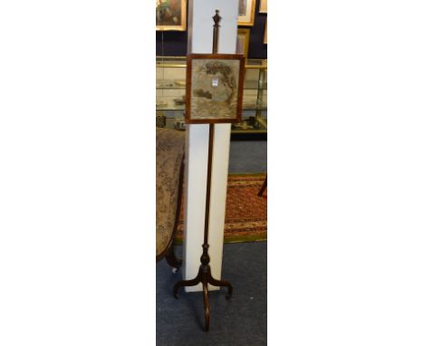 An early 19th century mahogany pole screen, with stumpwork panel, raised on tripod supports, 155cm high