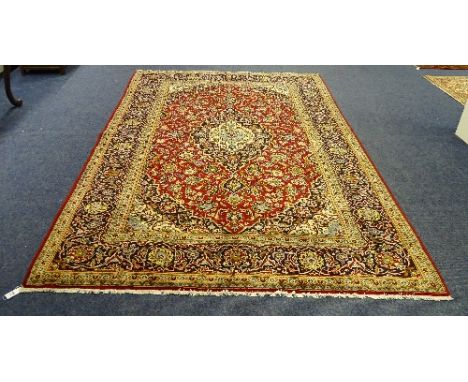 A Meshed carpet, with central foliate cream and blue medallion on red ground, with cream and blue corners and multiple beige 