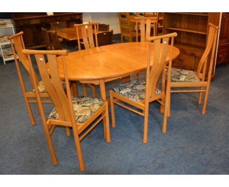 A blonde Ercol table with six chairs, light ash colour, the table of oval shape, 74cm high x 160cm long x 107cm wide, the cha