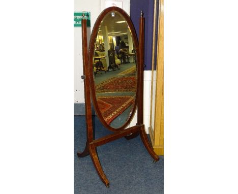 An Edwardian mahogany inlaid cheval mirror, the oval swing mirror flanked with a gilt metal urn finial, raised on lyre suppor