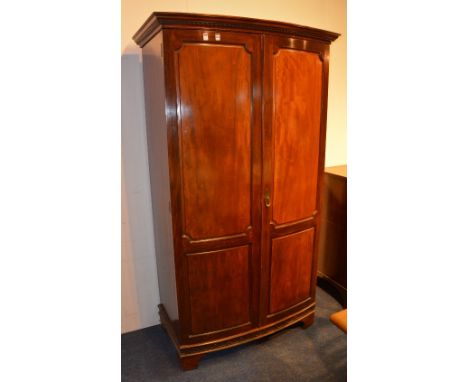 A Whytock & Reid mahogany wardrobe circa early 20th century, with dentil cornice above two panelled doors, raised on bracket 