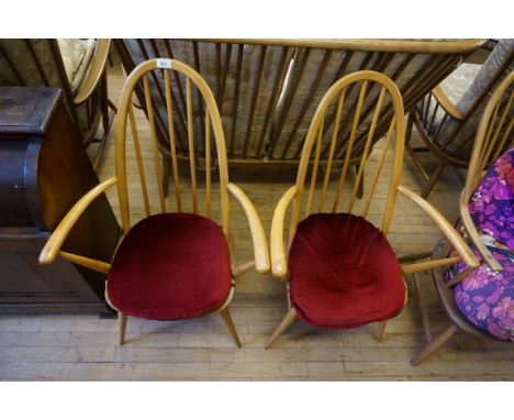 A pair of Ercol light wood stick back open armchairs.