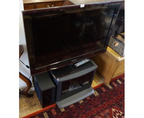 A Samsung 40inch flat screen TV, with remote, TV stand, Blue Ray player, speaker systems, etc. 