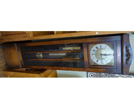 An early 20th Century glazed oak cased chiming longcase clock, having a silvered chapter ring, flanked by cherubic spandrels,