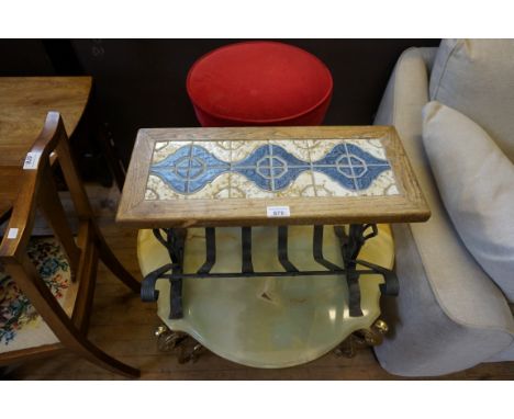 A stylish wrought iron magazine rack, with tiled wooden top, together with a cast iron 'Britannia-style' bar stool with uphol