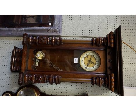 A 19th Century glazed walnut cased wall clock, of architectural form, having enamelled and gilt brass circular dial incorpora