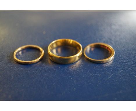 A Gents 18ct gold band, together with, a Ladies 22ct gold band, a 9ct gold and ruby half hoop eternity ring (3), weight combi