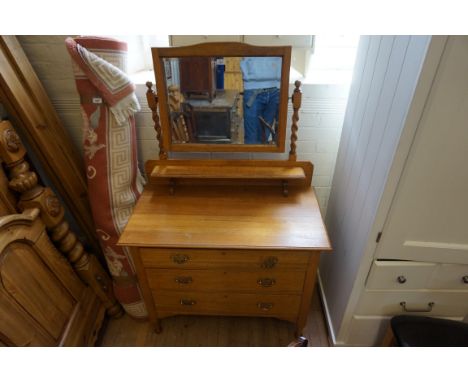 An Edwardian light oak dressing chest, having a bevelled swing mirror on barleytwist uprights above trinket shelf, with three