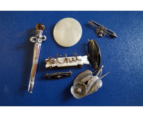 A Scottish silver agate kilt pin, in the form of a dagger, together with, a black enamel oval brooch, two mother of pearl bro