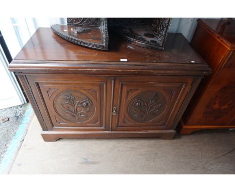 An Edwardian walnut sideboard, featuring two foliate carved panelled doors, raised on plinth and bracket base.