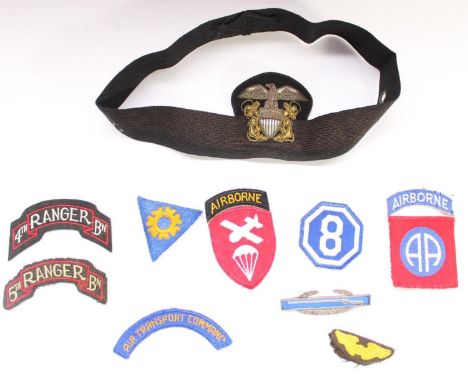 Collection of WWII era US military cloth and bullion patches and badges, including a US Navy Officers hat badge and band, 4th