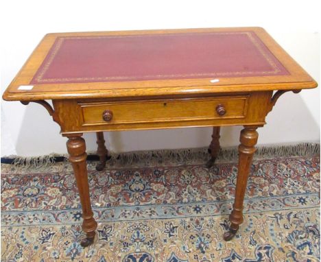 Victorian golden oak writing table, with inset gilt tooled top and one real and one faux drawers, on turned supports with cer