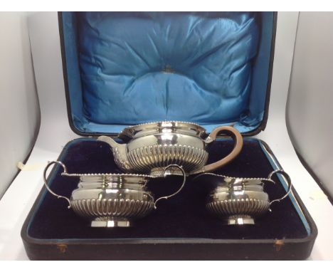 An Edwardian silver  three-piece silver tea set, of compressed globular form with gadrooned rim and half-reeded body, applied