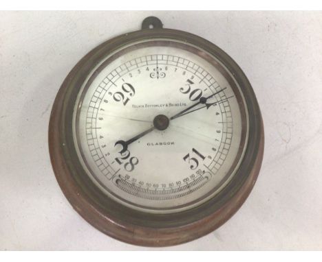 A bulk head style brass cased barometer by 'Kelvin Bottomley &amp; Baird Ltd Glasgow, mounted on circular wooden plinth, dial