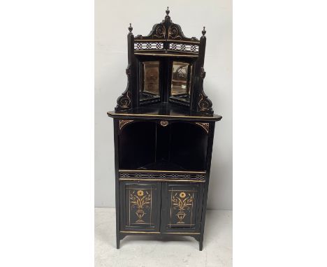 An aesthetic movement ebonised and gilt highlighted corner cupboard with shaped fretwork top, pair of bevelled mirrors, open 