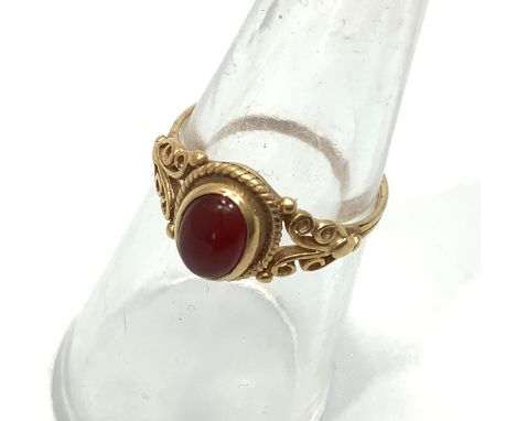 A 9ct yellow gold dress ring set with an oval orange cabochon cut stone in a rub over setting, weighs 2.0 grams, finger size 