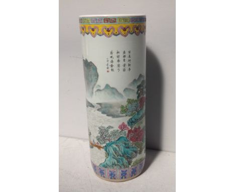 An Chinese porcelain stick stand of cylindrical form painted in polychrome enamels with mountain landscape and poem, continuo