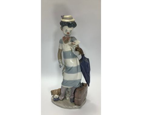 A Lladro porcelain figure of a young man dressed as a clown / pierrot holding a flower with umbrella over his arm and a dog a
