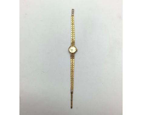 A ladies 9ct gold Rotary wristwatch with round champagne coloured face, batons denoting numbers, weighs 13.6 grams. 