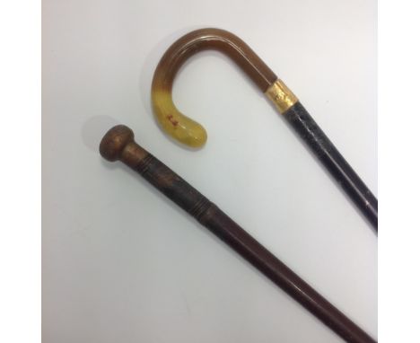 A Victorian sword stick with engraved brass pommel and ferrule, together with another walking stick with amber handle and 18c