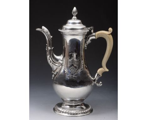 A GEORGE III SILVER COFFEE POT of baluster form and standing on a fluted turned stepped foot, domed hinged lid with flame fin