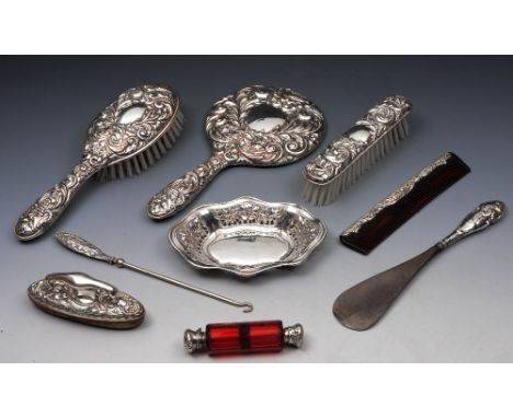 A COLLECTION TO INCLUDE: two silver backed brushes, a comb, a hand mirror, a nail buff, shoe horn, button hook, a tray, and a