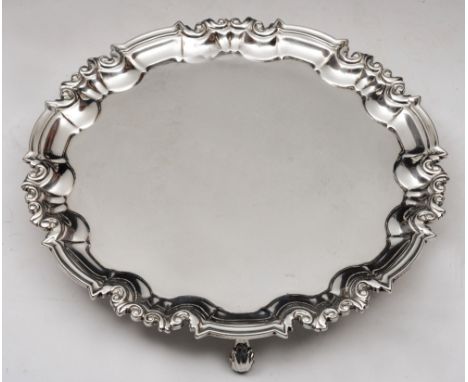 A LATE VICTORIAN SILVER SALVER with a scroll and shaped border and three scroll feet, 20.5cm diameter, London 1896 by William