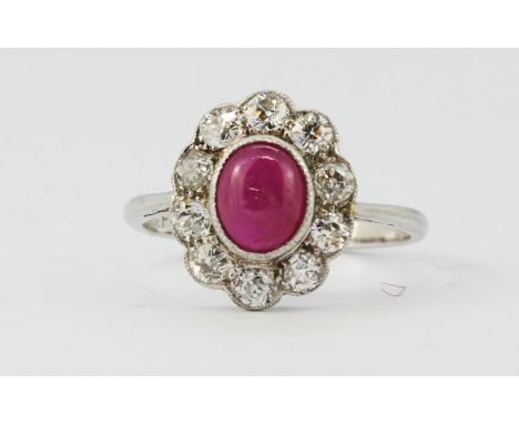 An 18ct white gold cluster ring set with a cabochon cut ruby surrounded by brilliant cut diamonds, approx. 0.90ct diamonds ov