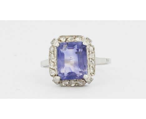 A white metal (tested platinum) ring set with an emerald cut sapphire and rose cut diamonds, (N).