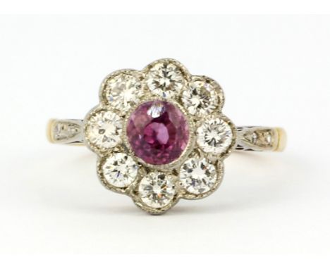 An 18ct yellow and white gold (stamped 18ct) cluster ring set with a pink sapphire and diamonds, approx. 0.80ct, (N.5).