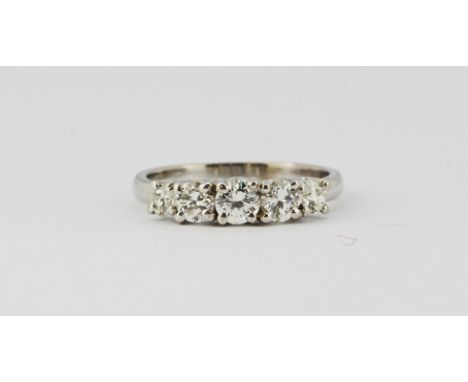 A white metal (tested 18ct gold) ring set with five brilliant cut diamonds, approx. 1ct, (N.5).