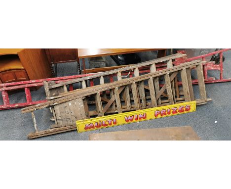 A group of vintage wooden ladders and two signs.