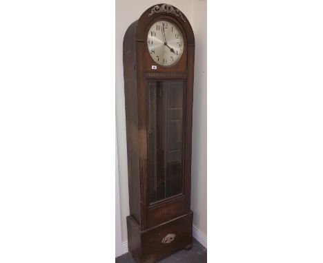 An Oak Longcase Clock, having an arched top enclosing a silvered dial with Arabic numerals and with a striking and chiming mo