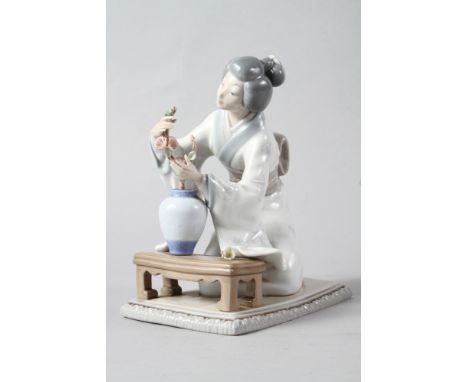 A Lladro figure of a Geisha arranging flowers in a vase, 7 3/4" high 