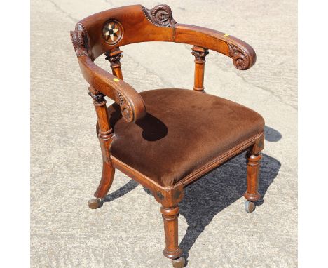 A mid Victorian oak and ivory inlaid desk elbow chair with fern carved terminals, on faceted castored supports 