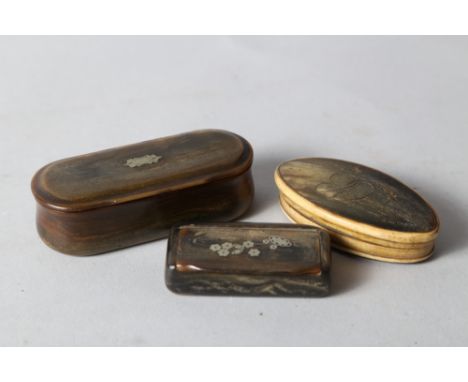 A 19th century oval horn snuff box, 3 1/4" wide, a larger similar snuff box, 4" wide, and one other snuff box with white meta