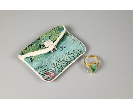 A marquis-shaped green jade set ring, unmarked yellow metal, with engraved shoulders, size M