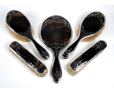 A silver and tortoiseshell piqué five-piece brush set including hand mirror, Mappin &amp; Webb, Birmingham 1913/15