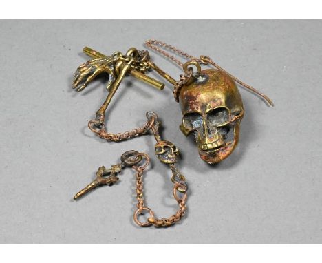 A vintage gilt brass watch chain hung with a skull fob pill-box with hinged jaw retained by a pin, also with skeletal hand an