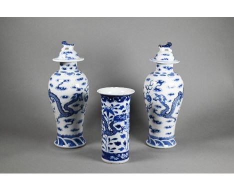 A pair of 19th century Chinese blue and white baluster vases with domed covers surmounted by guardian lion finials in the Kan