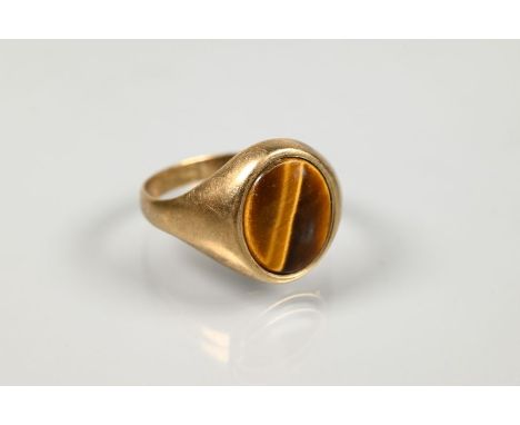 A signet ring set oval tiger's eye in 9ct yellow gold, size S 1/2