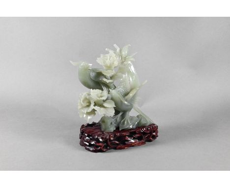 A Chinese celadon 'new jade' bowenite ornament carved as two exotic birds perching amongst foliage and rockwork, 15 cm high c