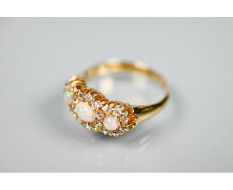 A Victorian opal and diamond cluster ring, the graduated circular opals surrounded by old cut diamonds, in 18ct yellow gold s