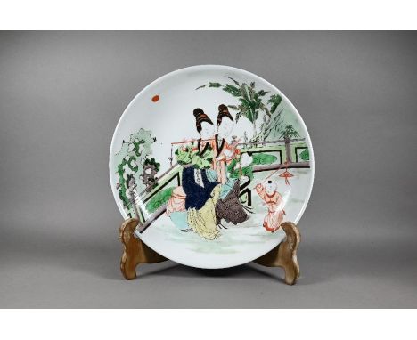A Chinese famille verte shallow bowl or charger painted in polychrome enamels with two female musicians with children in a fe